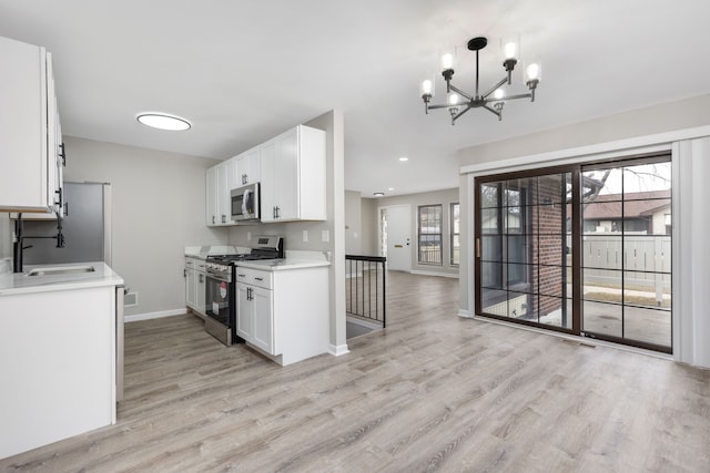 kitchen with stainless steel appliances, plenty of natural light, light countertops, and white cabinets