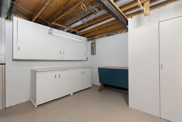 unfinished basement featuring electric panel and light floors