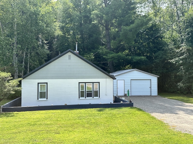 view of front facade featuring a garage, a front lawn, an outbuilding, and concrete block siding