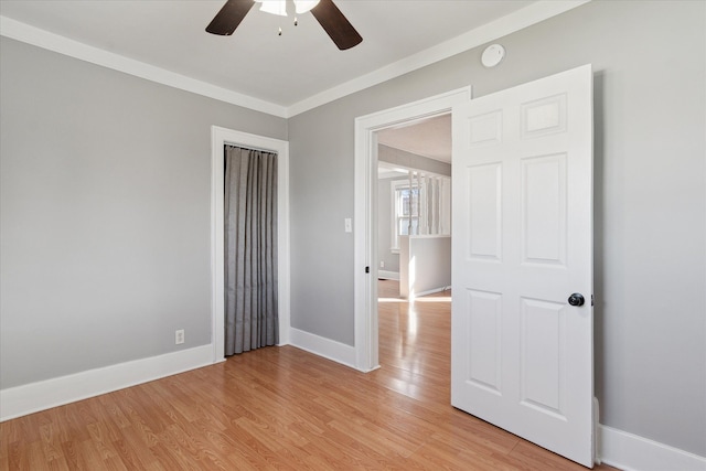 unfurnished room with light wood finished floors, ceiling fan, baseboards, and ornamental molding