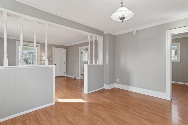 spare room with light wood-style floors, baseboards, and crown molding