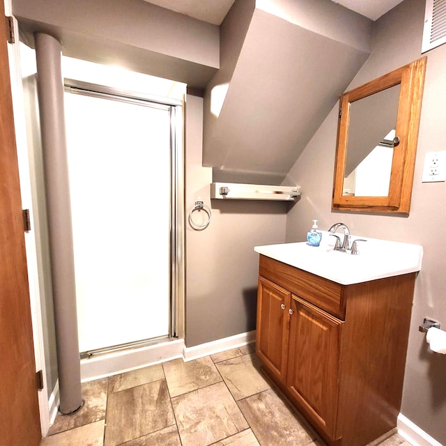 bathroom with vaulted ceiling, vanity, visible vents, and baseboards