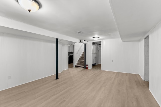 finished basement with stairway, wood finished floors, and visible vents