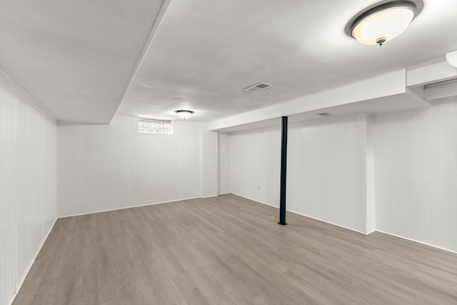 finished basement with visible vents and wood finished floors