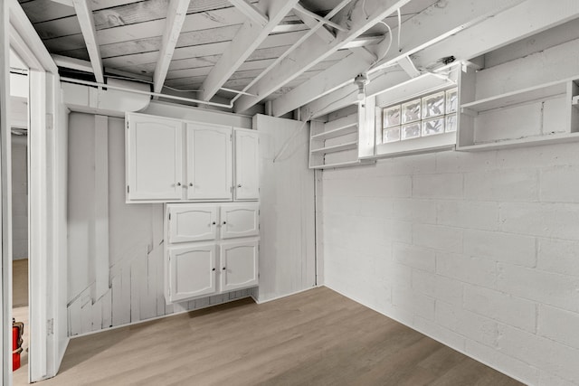 basement with concrete block wall and light wood-style floors