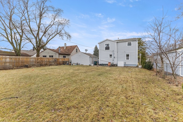 rear view of property with a yard and fence