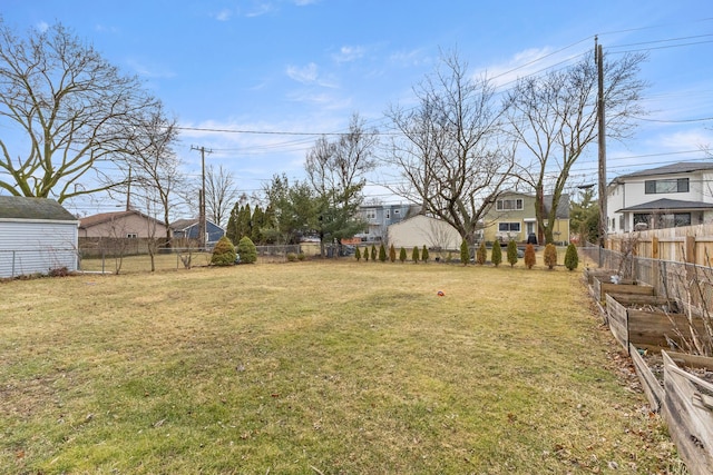 view of yard featuring a garden, a residential view, and a fenced backyard