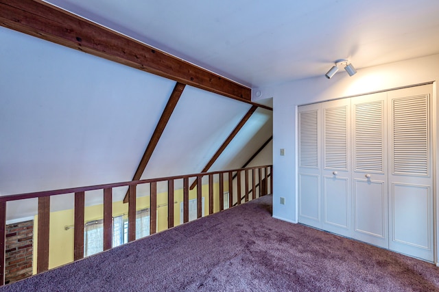 bonus room with lofted ceiling with beams and carpet