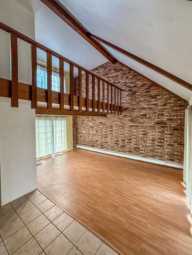 unfurnished living room with brick wall, high vaulted ceiling, beam ceiling, and tile patterned floors