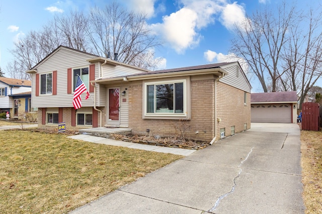 tri-level home with a front lawn, an outbuilding, brick siding, and a detached garage