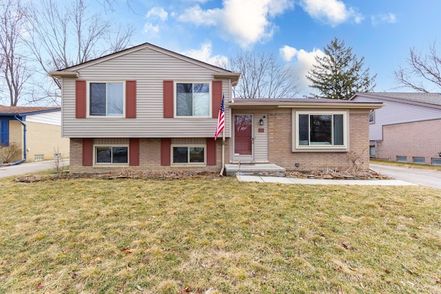 split level home with a front yard and brick siding