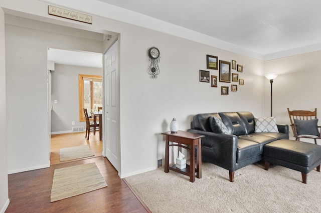 living room with visible vents, baseboards, and wood finished floors