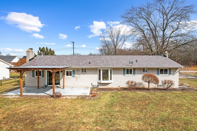 back of property featuring brick siding, a patio, a chimney, and a lawn