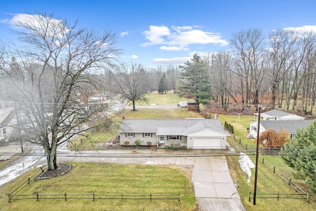 view of front of house featuring driveway, an attached garage, fence, and a front yard