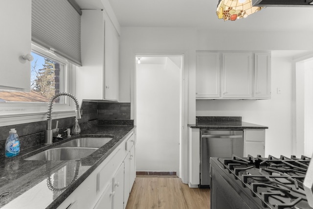 kitchen featuring gas stove, white cabinetry, light wood-style flooring, a sink, and stainless steel dishwasher