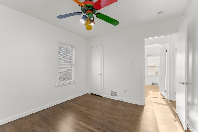 unfurnished bedroom with visible vents, wood finished floors, and baseboards