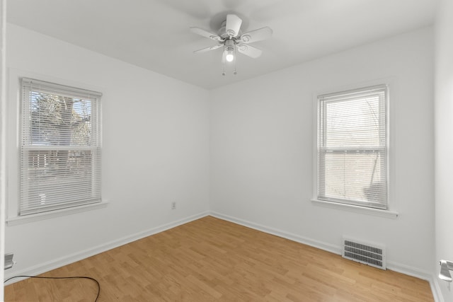 unfurnished room with visible vents, light wood-style flooring, baseboards, and ceiling fan