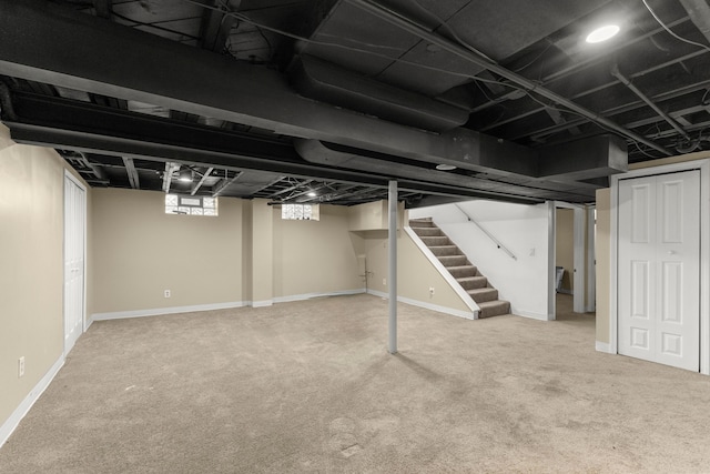 basement featuring stairway, carpet flooring, and baseboards