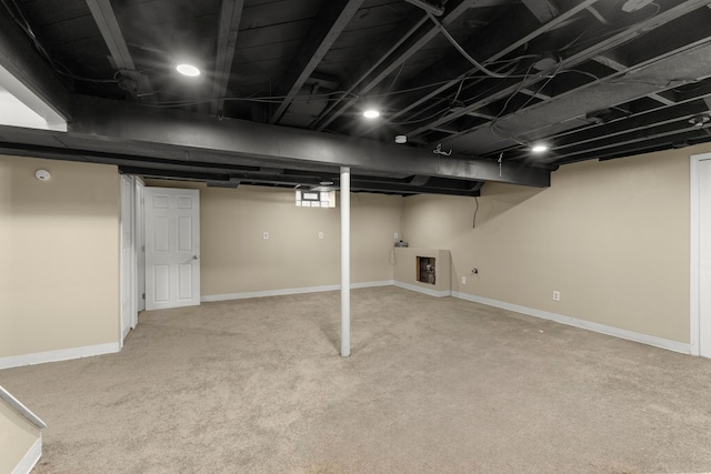 below grade area featuring baseboards and carpet floors