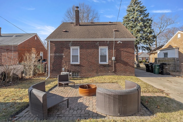 rear view of property with a patio, fence, brick siding, and a chimney