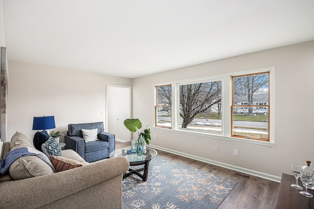 living area featuring visible vents, baseboards, and wood finished floors