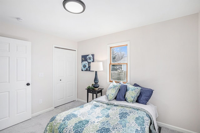 bedroom featuring light carpet, a closet, and baseboards