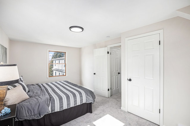 bedroom featuring light colored carpet and baseboards