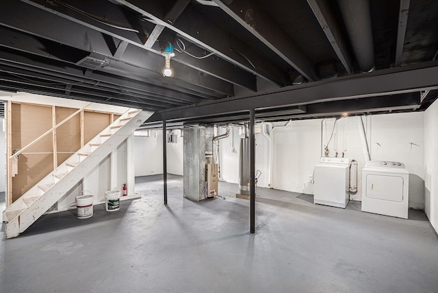 unfinished below grade area featuring washer and dryer, stairway, and heating unit