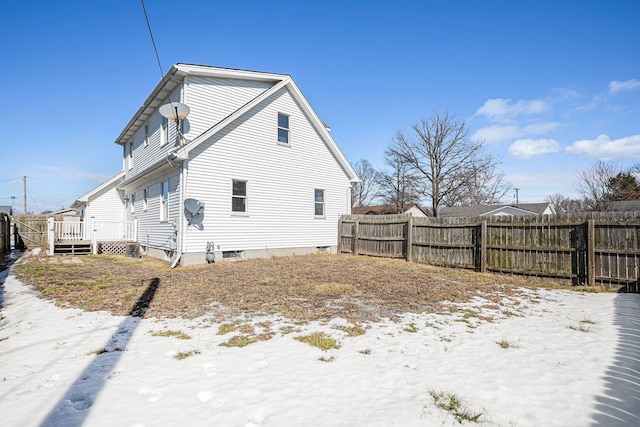 snow covered property featuring fence and a wooden deck