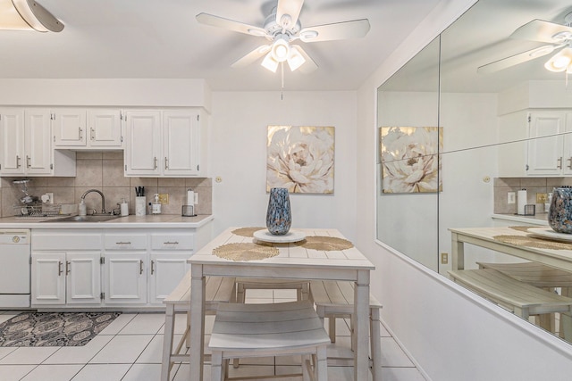 kitchen featuring light countertops, light tile patterned flooring, ceiling fan, a sink, and dishwasher