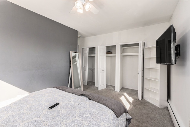 carpeted bedroom with a baseboard heating unit, multiple closets, and a ceiling fan