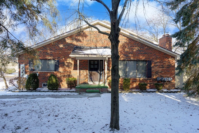 view of front of house with brick siding and a chimney