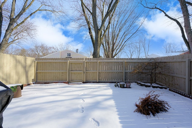 yard covered in snow featuring a fenced backyard