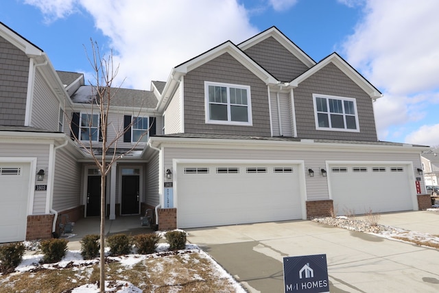 view of front of house featuring a garage, concrete driveway, and brick siding