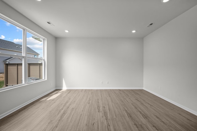 spare room featuring visible vents, baseboards, wood finished floors, and recessed lighting