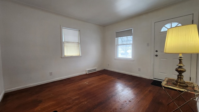 entryway featuring baseboards, hardwood / wood-style flooring, visible vents, and a healthy amount of sunlight