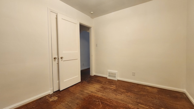 unfurnished bedroom featuring dark wood finished floors, visible vents, and baseboards