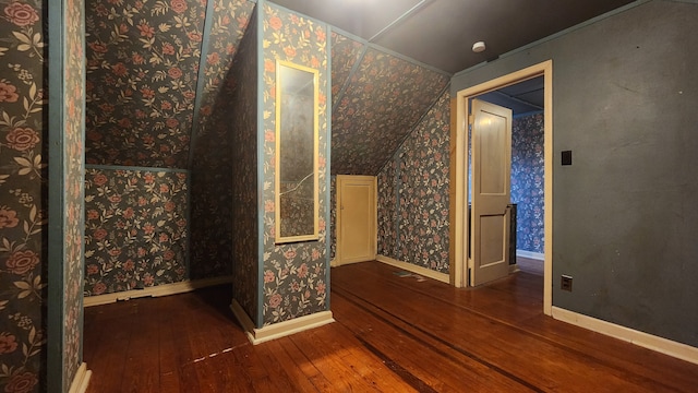 bonus room with wood-type flooring, vaulted ceiling, baseboards, and wallpapered walls