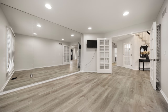 empty room with light wood-type flooring, recessed lighting, baseboards, and french doors