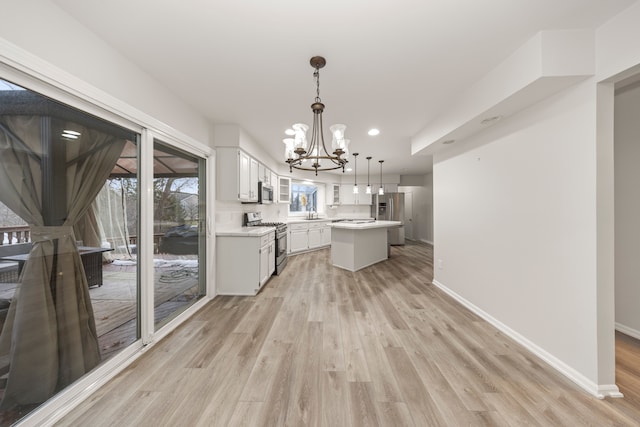 kitchen with baseboards, light countertops, appliances with stainless steel finishes, and light wood-style floors