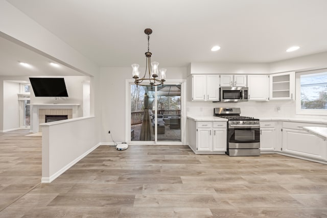 kitchen featuring stainless steel appliances, light wood-type flooring, white cabinets, and light countertops