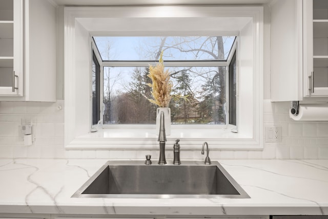 kitchen with white cabinets, glass insert cabinets, backsplash, and a sink