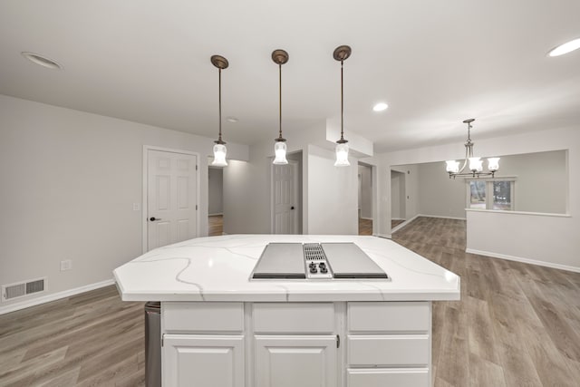 kitchen featuring visible vents, baseboards, light wood-style floors, white cabinets, and an inviting chandelier