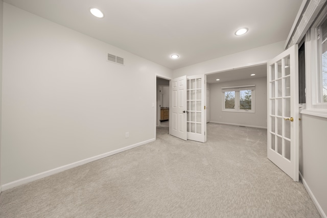 carpeted empty room with recessed lighting, baseboards, visible vents, and french doors