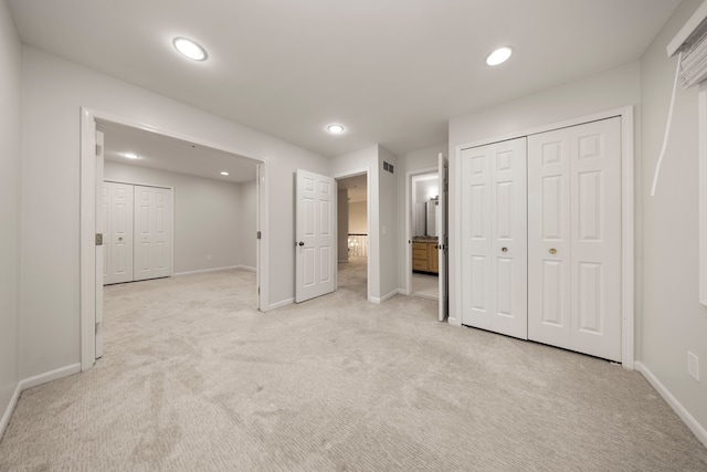 unfurnished bedroom with visible vents, baseboards, light colored carpet, a closet, and recessed lighting