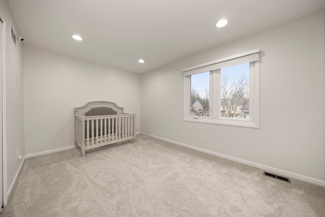 unfurnished bedroom featuring carpet, visible vents, baseboards, and recessed lighting