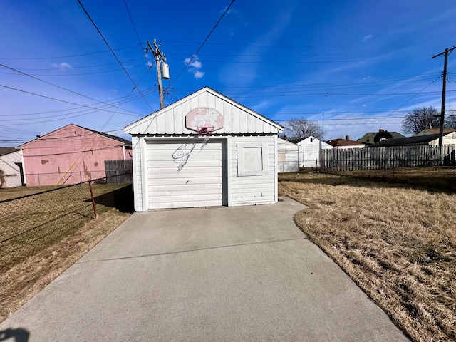 view of outdoor structure with driveway, an outdoor structure, and fence