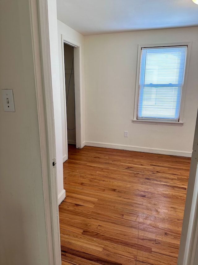 spare room featuring wood finished floors and baseboards