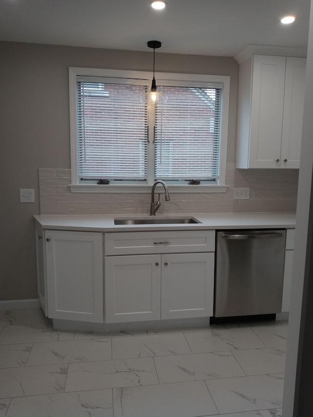 kitchen featuring a sink, marble finish floor, plenty of natural light, and dishwasher