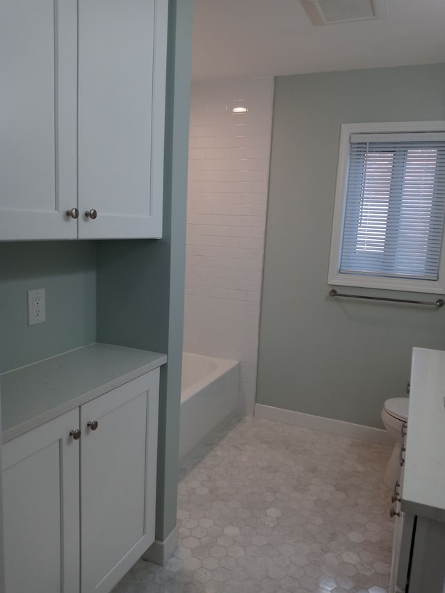 bathroom featuring baseboards, vanity, and toilet